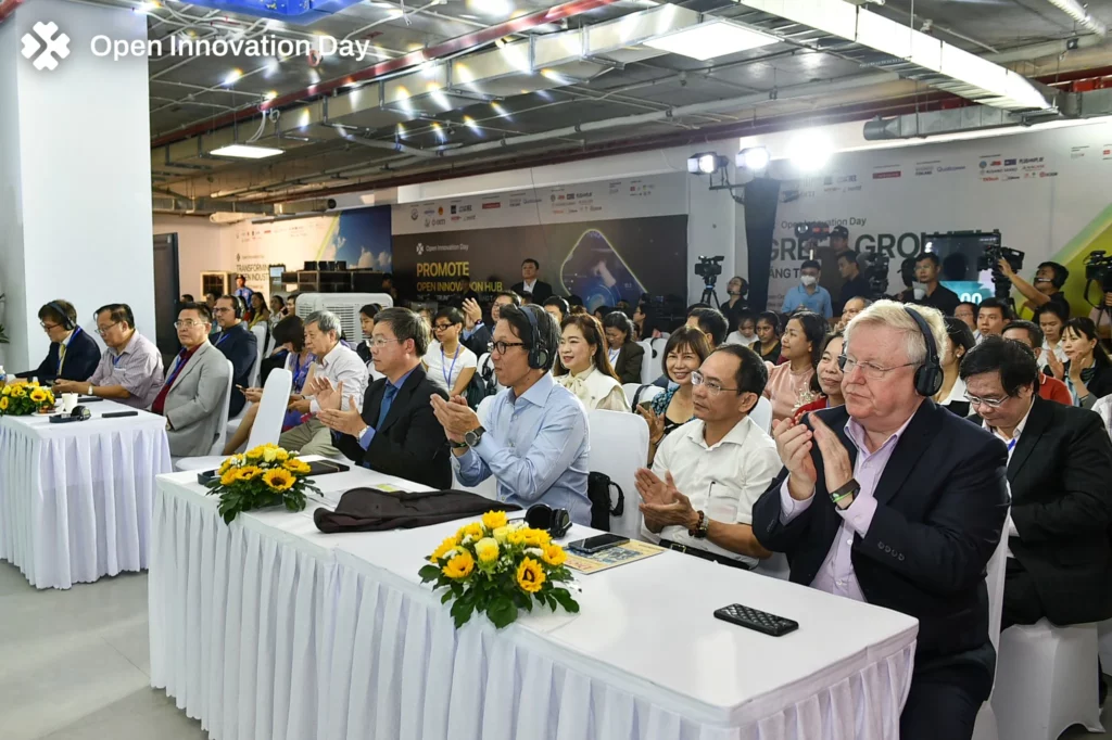 A group of people sitting at a table and clapping.