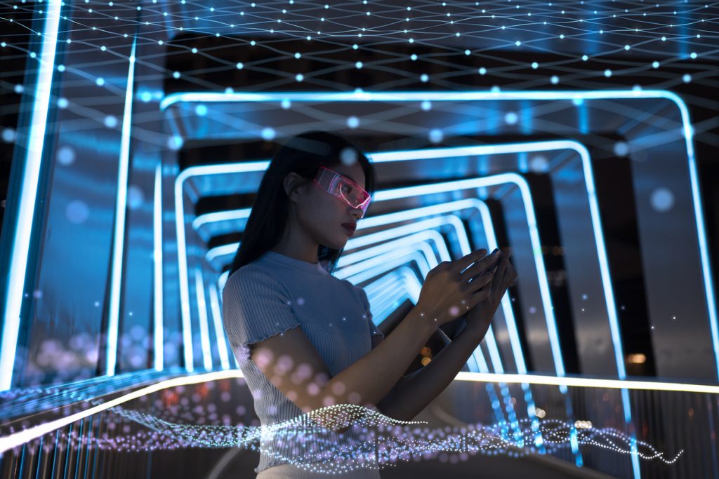 A woman wearing augmented reality glasses interacts with holographic interfaces in a futuristic setting illuminated by neon lights.